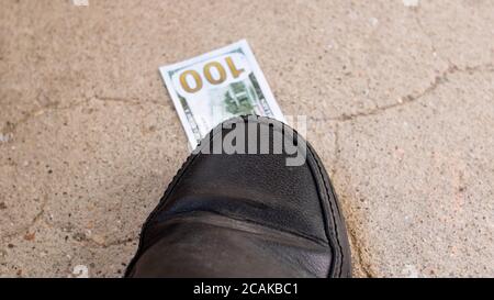 Ein 100-Dollar-Schein unter dem Schuh Stockfoto