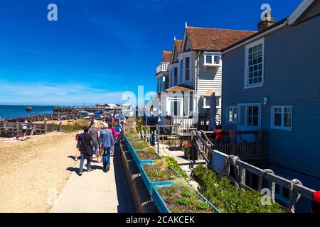 Menschen, die entlang der Küste in Whitestable, Kent, Großbritannien, wandern Stockfoto