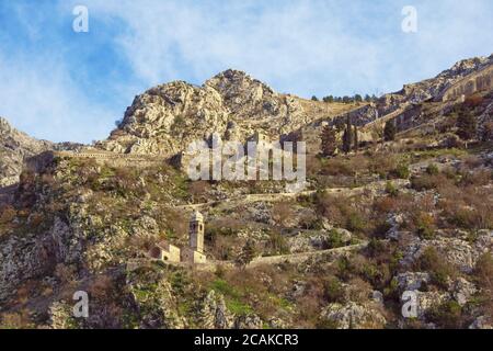 Alte Befestigungsanlagen. Montenegro, Kotor Stadt. Blick auf die Straße zur Festung Kotor und die Kirche unserer Lieben Frau von Remedy am Wintertag Stockfoto