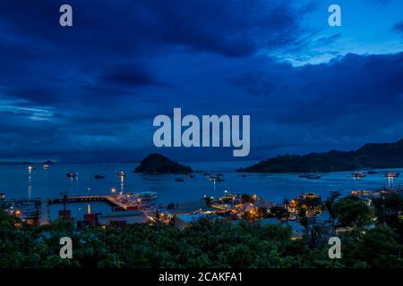 Hügeloberblick über den Hafen Labuan Bajo in der Abenddämmerung, Flores, Indonesien Stockfoto