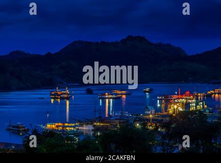 Blick über den Hafen von Labuan Bajo und die nahe gelegene Insel bei Nacht, Flores, Indonesien Stockfoto