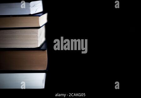 Ein Stapel Bücher auf schwarzem Hintergrund Stockfoto