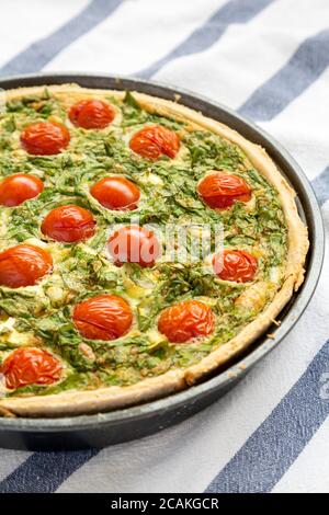 Hausgemachter Spinat Quiche in einer Auflaufform, Seitenansicht. Nahaufnahme. Stockfoto