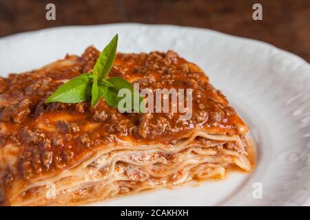 Ein Stück Lasagne auf einem Holztisch Stockfoto