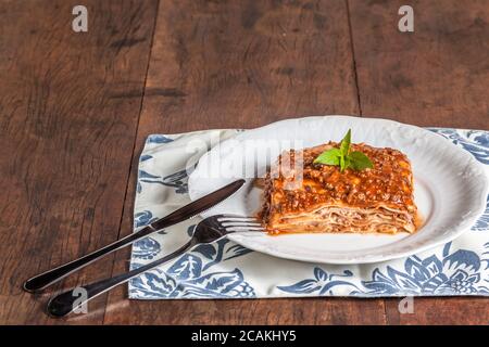 Ein Stück Lasagne auf einem Holztisch Stockfoto