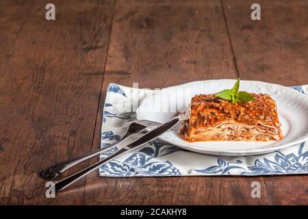 Ein Stück Lasagne auf einem Holztisch Stockfoto