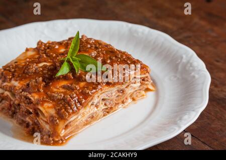 Ein Stück Lasagne auf einem Holztisch Stockfoto