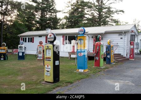 Sammlung von Vintage-Gaspumpen und Schilder auf Wohnfront Rasen, New Hampshire, USA Stockfoto