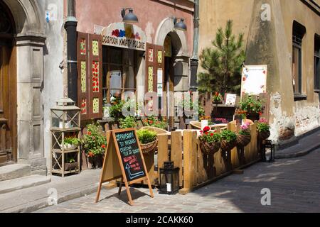 September 2019 - Warschau/Polen: Terrasse mit Blumen und Außenansicht eines traditionellen polnischen Restaurants in der Altstadt von Warschau Stockfoto