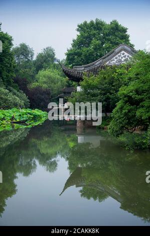 Ein traditionelles chinesisches Gebäude mit Blick auf einen Lotusteich in den Guyi Gärten Shanghai China. Stockfoto