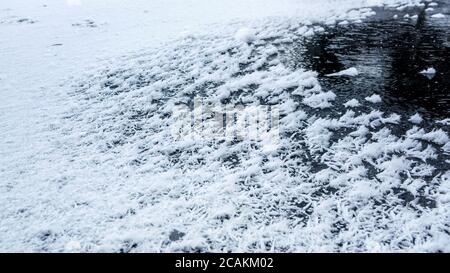 Kristalliner Schnee, Schneeflocken Detail sichtbar, auf Eis auf gefrorenen Teich gebildet Stockfoto