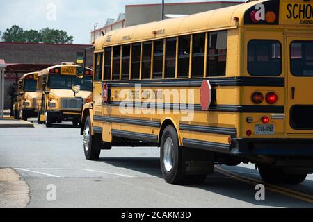 Kanton, GA, USA. August 2020. Cherokee High School Busse verlassen Schule mit Schülern am Ende der ersten Woche der in-Person fallen Klassen während Pandemie Sorgen. Das Schulsystem Mandatsmasken für alle Lehrkräfte und Mitarbeiter, lehnte es jedoch ab, darauf zu bestehen, dass die Schüler sie tragen. Administratoren räumten ein, dass der Landkreis unter einem Ã“nationalen microscopeÃ steht, da er die Präsenzklassen wiedereröffnete, da Covid-19-Fälle in Georgien anstiegen. Quelle: Robin Rayne/ZUMA Wire/Alamy Live News Stockfoto