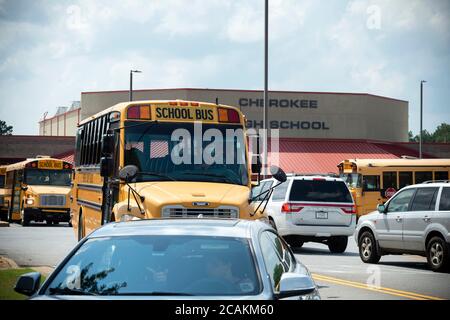 Kanton, GA, USA. August 2020. Cherokee High School Busse verlassen Schule mit Schülern am Ende der ersten Woche der in-Person fallen Klassen während Pandemie Sorgen. Das Schulsystem Mandatsmasken für alle Lehrkräfte und Mitarbeiter, lehnte es jedoch ab, darauf zu bestehen, dass die Schüler sie tragen. Administratoren räumten ein, dass der Landkreis unter einem Ã“nationalen microscopeÃ steht, da er die Präsenzklassen wiedereröffnete, da Covid-19-Fälle in Georgien anstiegen. Quelle: Robin Rayne/ZUMA Wire/Alamy Live News Stockfoto