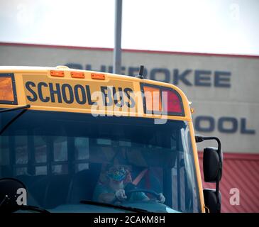 Kanton, GA, USA. August 2020. Cherokee High School Busse verlassen Schule mit Schülern am Ende der ersten Woche der in-Person fallen Klassen während Pandemie Sorgen. Das Schulsystem Mandatsmasken für alle Lehrkräfte und Mitarbeiter, lehnte es jedoch ab, darauf zu bestehen, dass die Schüler sie tragen. Administratoren räumten ein, dass der Landkreis unter einem Ã“nationalen microscopeÃ steht, da er die Präsenzklassen wiedereröffnete, da Covid-19-Fälle in Georgien anstiegen. Quelle: Robin Rayne/ZUMA Wire/Alamy Live News Stockfoto