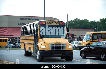 Kanton, GA, USA. August 2020. Cherokee High School Busse verlassen Schule mit Schülern am Ende der ersten Woche der in-Person fallen Klassen während Pandemie Sorgen. Das Schulsystem Mandatsmasken für alle Lehrkräfte und Mitarbeiter, lehnte es jedoch ab, darauf zu bestehen, dass die Schüler sie tragen. Administratoren räumten ein, dass der Landkreis unter einem ''˜nationalen Mikroskop' steht, da er die Präsenzklassen wiedereröffnete, da Covid-19 Fälle in Georgien anstiegen. Quelle: Robin Rayne/ZUMA Wire/Alamy Live News Stockfoto