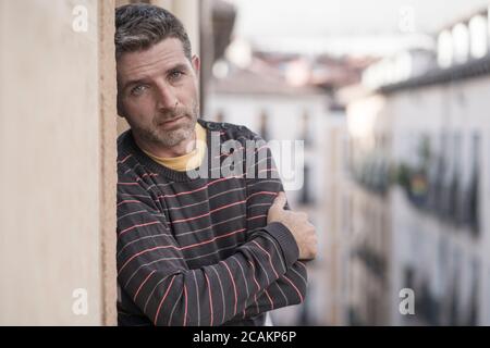 Urban Lifestyle emotionales Porträt der 40er Jahre schöner Mann traurig und Deprimiert zu Hause Balkon lehnend aufgeregt Gefühl besorgt leiden Depression Problem lo Stockfoto