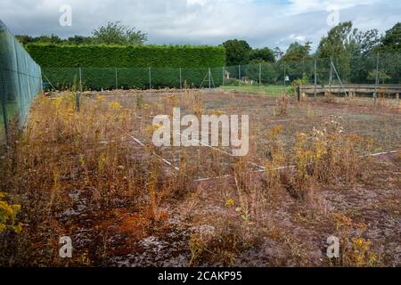 Stillgelegte Tennisplatz in schlechtem Zustand Stockfoto