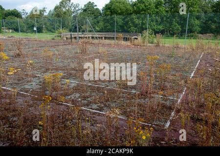Stillgelegte Tennisplatz in schlechtem Zustand Stockfoto