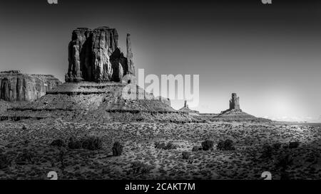 Schwarz-Weiß-Foto der hoch aufragenden roten Sandsteinformation von West Mitten Butte im Monument Valley der Navajo Nation, Utah, USA Stockfoto