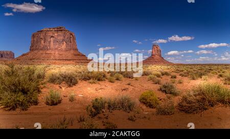 Die Sandsteinformationen Merrick Butte und East Mitten Butte in der Wüstenlandschaft des Monument Valley Navajo Tribal Park im Süden Utahs, vereint Stockfoto