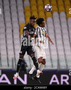 Turin. August 2020. FC Juventus' Juan Cuadrado (R) siegt mit Olympique Lyonnais' Maxwel Cornet während des UEFA Champions League-Spiels von 16 2. Etappe zwischen FC Juventus und Olympique Lyonnais in Turin, Italien, am 7. August 2020. Quelle: Federico Tardito/Xinhua/Alamy Live News Stockfoto