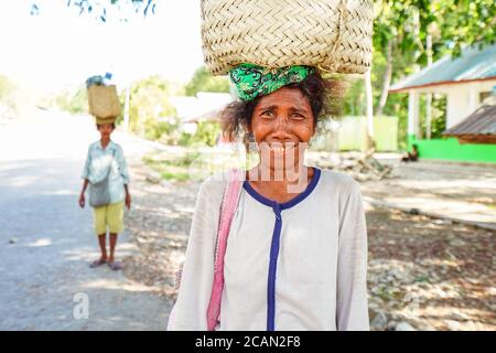 Haikesa / Indonesien - 10. August 2018: Porträt einer erwachsenen Frau, die Bündel auf dem Kopf in einem ländlichen Dorf trägt Stockfoto