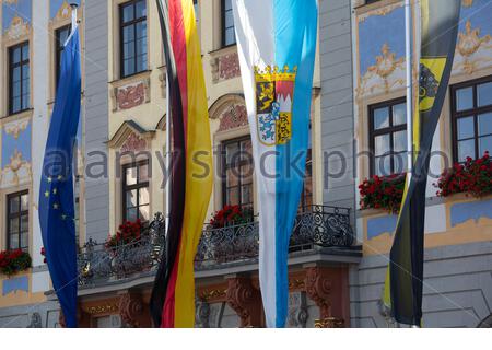 Vier Flaggen hängen im Sonnenschein auf dem Rathaus von Coburg in Bayern, die EU-Flagge, die deutsche Flagge sowie die bayerische und die Coburger Flagge. Stockfoto