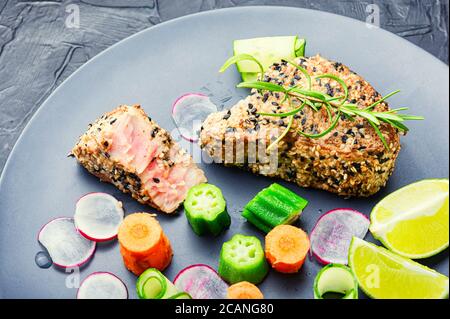 Gebackenes Thunfischsteak mit Gemüsegarnierung.Fisch mit Gemüse gekocht. Stockfoto