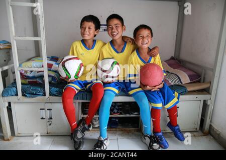 Weining, Chinas Provinz Guizhou. August 2020. Drei Spieler der Fußballmannschaft "Green Pepper" posieren in ihrem Schlafsaal in den autonomen Bezirken Yi, Hui und Miao in Weining, südwestlich der Provinz Guizhou, am 7. August 2020. Über 40 lokale Studenten bildeten eine Fußballmannschaft namens "Green Pepper" und widmeten sich dem Fußballtraining während der Sommerferien in Shimen Township in Weining County, einem ländlichen Ort mit einer durchschnittlichen Höhe von über 2,000 Metern. Quelle: Liu Xu/Xinhua/Alamy Live News Stockfoto