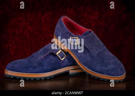Herren Leder-Slipper blau auf rotem Hintergrund. Stylische Herrenschuhe Stockfoto