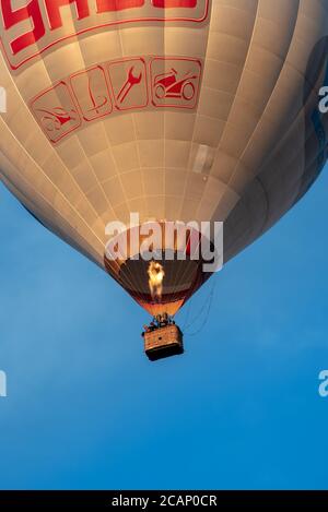 Vilnius/Litauen - 2020-08-02: Heißluftballons von unten wüten durch einen klaren, hellblauen Himmel mit vielen Menschen im Inneren Stockfoto