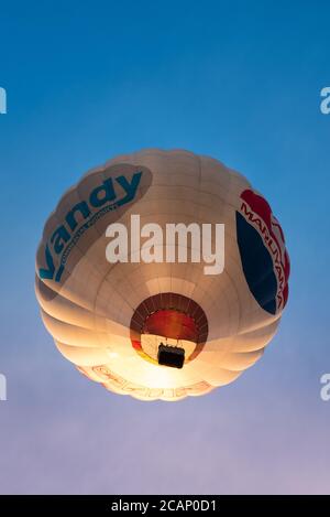 Vilnius/Litauen - 2020-08-02: Heißluftballons von unten wüten durch einen klaren, hellblauen Himmel mit vielen Menschen im Inneren Stockfoto