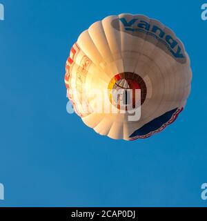 Vilnius/Litauen - 2020-08-02: Heißluftballons von unten wüten durch einen klaren, hellblauen Himmel mit vielen Menschen im Inneren Stockfoto