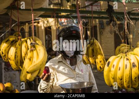 jaisalmer, rajasthan / indien - april 20 2020 : Mann verkauft Früchte tragen Maske und Helm zum Schutz Stockfoto