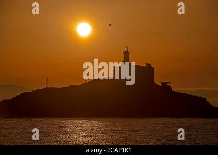 Murmbles, Swansea, Großbritannien. August 2020. Die Sonne geht heute Morgen über dem Mumbles Lighthouse in der Nähe von Swansea auf, zu Beginn eines atemberaubenden Sommertages in Großbritannien. Quelle: Phil Rees/Alamy Live News Stockfoto