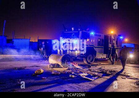 Kapstadt, SÜDAFRIKA – August 07 2020: In der New Eisleben Road stehen Mitglieder der südafrikanischen Polizei in einem Nyala gepanzerten Fahrzeug ab, nachdem Demonstranten am Abend des 07. August 2020 in Kapstadt, Südafrika, die Straße mit Betonrohren und großen Felsen in Philippi verbarrikadiert hatten. Demonstranten plünderten eine kleine Handy-Werkstatt. (Foto von Roger Sedres) Quelle: Roger Sedres/Alamy Live News Stockfoto