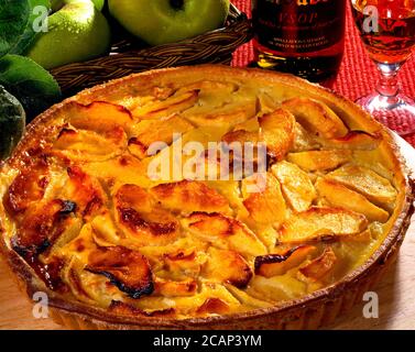 Französische Apfeltarte mit Korb aus grünen Äpfeln und Glas Von Calvados Stockfoto