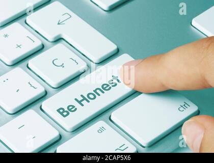 Be Honest Written on Blue Key of Metallic Keyboard. Drücken Sie die Taste mit dem Finger. Stockfoto