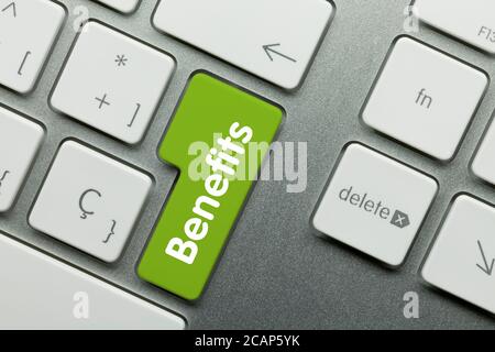 Vorteile auf Green Key der metallischen Tastatur geschrieben. Drücken Sie die Taste mit dem Finger. Stockfoto