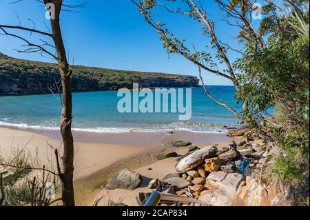 Blick auf Wattamolla Beach Blue Water und Blue Sky Providential Foot Track an einem sonnigen Winternachmittag Stockfoto