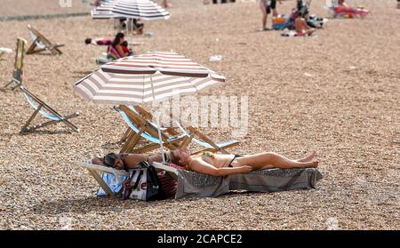 Brighton UK 8. August 2020 - Sonnenanbeter am Brighton Strand, da die Temperatur in einigen Teilen des Südostens voraussichtlich über 30 Grad erreichen wird : Credit Simon Dack / Alamy Live News Stockfoto