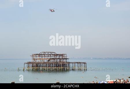 Brighton UK 8. August 2020 - der Hubschrauber der Küstenwache über Brighton's West Pier, da die Temperatur in einigen Teilen des Südostens voraussichtlich über 30 Grad erreichen wird : Credit Simon Dack / Alamy Live News Stockfoto