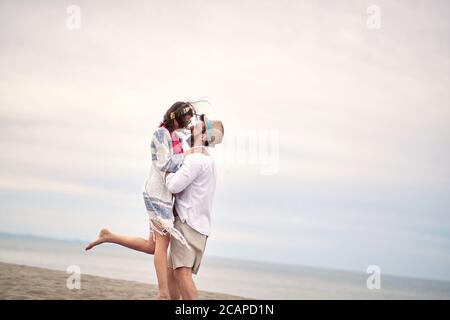 kaukasischer bärtiger Kerl umarmt seine Freundin und hebt sie auf Stockfoto