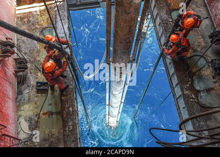 (200808) -- HAIKOU, 8. August 2020 (Xinhua) -- Arbeiter erfüllen eine Bohraufgabe auf der Kantan No.3 Offshore-Ölplattform in den nördlichen Gewässern des Südchinesischen Meeres, 27. Juli 2020. Die Kantan No.3 ist eine semi-tauchfähige Ölplattform, die 1983 von China im Inland entwickelt wurde. Seine 18 Bohrteam-Mitglieder arbeiten 12-Stunden-Schichten non-stop, um marine Öl-und Gas-Ressourcen, die oft in Meeresböden gefunden werden 5,000 bis 6,000 Meter unter Wasser. Das Leben auf der Ölplattform ist geprägt von Mühsal und Langeweile, denn das Wetter ist heiß und es gibt kein Handy-Signal. In der Regel ist die gut- Stockfoto