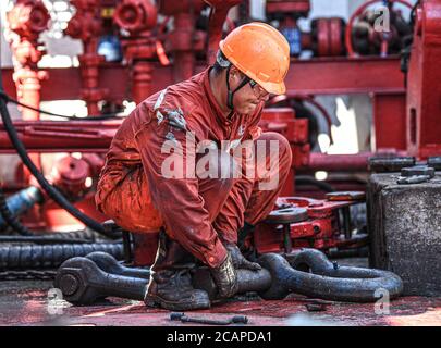 (200808) -- HAIKOU, 8. August 2020 (Xinhua) -- EIN Arbeiter erfüllt Bohrarbeiten auf der Kantan No.3 Offshore-Ölplattform in den nördlichen Gewässern des Südchinesischen Meeres, 23. Juli 2020. Die Kantan No.3 ist eine semi-tauchfähige Ölplattform, die 1983 von China im Inland entwickelt wurde. Seine 18 Bohrteam-Mitglieder arbeiten 12-Stunden-Schichten non-stop, um marine Öl-und Gas-Ressourcen, die oft in Meeresböden gefunden werden 5,000 bis 6,000 Meter unter Wasser. Das Leben auf der Ölplattform ist geprägt von Mühsal und Langeweile, denn das Wetter ist heiß und es gibt kein Handy-Signal. In der Regel ist die gut- Stockfoto