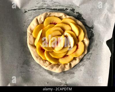 Rohe Peach Galette bereit zum Kochen auf Backblech mit Backpapier Blatt / Nectarine Fruit Pie Torte. Gesundes Bio-Dessert. Stockfoto