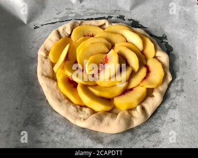 Rohe Peach Galette bereit zum Kochen auf Backblech mit Backpapier Blatt / Nectarine Fruit Pie Torte. Gesundes Bio-Dessert. Stockfoto