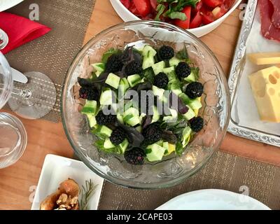 Brombeerfruchtsalat mit Tzatziki - traditionelle griechische Joghurt-/Joghurtsauce mit Gurke in Glasschüssel. Bereit zum Essen. Stockfoto