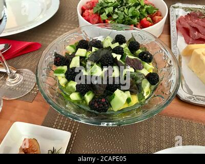 Brombeerfruchtsalat mit Tzatziki - traditionelle griechische Joghurt-/Joghurtsauce mit Gurke in Glasschüssel. Bereit zum Essen. Stockfoto