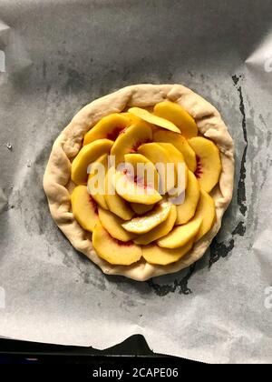 Rohe Peach Galette bereit zum Kochen auf Backblech mit Backpapier Blatt / Nectarine Fruit Pie Torte. Gesundes Bio-Dessert. Stockfoto